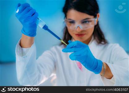 Student in White Coat, Working in Research Laboratory Using Micro Pipette and Test Tube