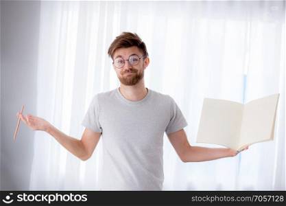 student man wear glasses holding a book empty with smiling happiness of study