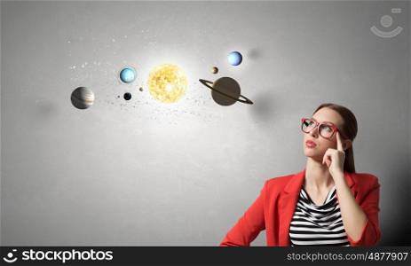 Student of astronomy faculty. Young pretty girl in red jacket and glasses and universe system