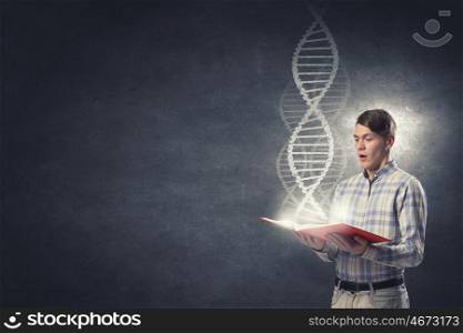 Student of biochemistry faculty. Young student guy with book in hands and DNA molecule on pages