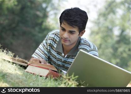 Student reading a book in a park