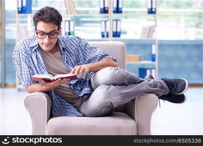 Student reading books and preparing for exams in library