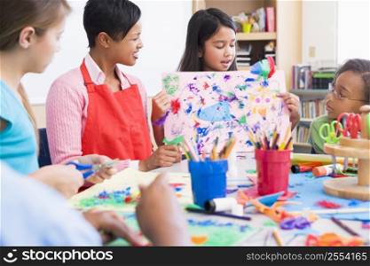 Student showing teacher and classmates her artwork (selective focus)