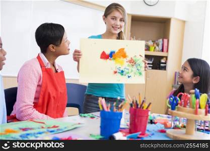 Student showing teacher and classmates her artwork (selective focus)