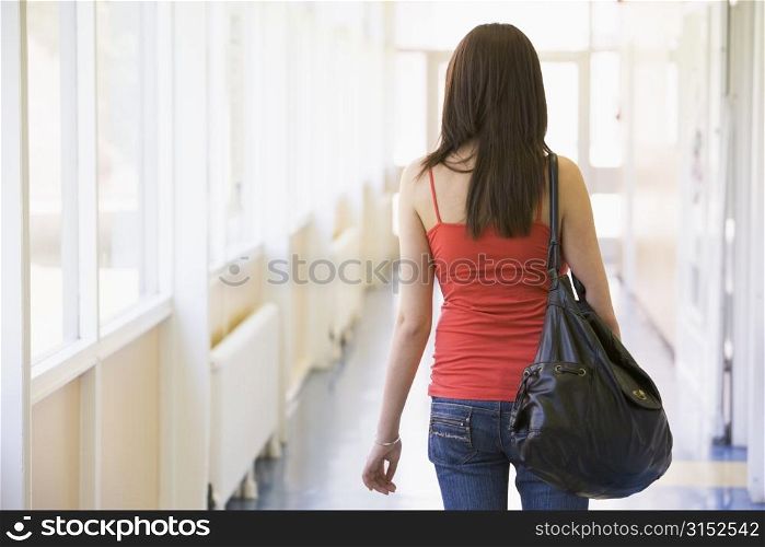 Student standing in corridor (high key)