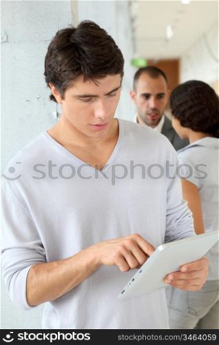 Student standing in hall with electronic tablet