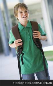 Student standing outside school smiling (selective focus)