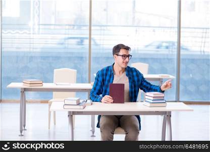 Student studying in the empty library with book preparing for ex. Student studying in the empty library with book preparing for exam. Student studying in the empty library with book preparing for ex