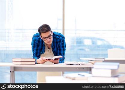 Student studying in the empty library with book preparing for exam. Student studying in the empty library with book preparing for ex