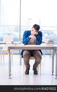 Student studying in the empty library with book preparing for exam. Student studying in the empty library with book preparing for ex