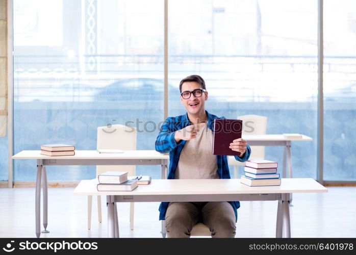 Student studying in the empty library with book preparing for exam. Student studying in the empty library with book preparing for ex