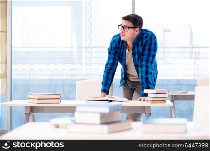 Student studying in the empty library with book preparing for exam. Student studying in the empty library with book preparing for ex