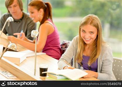 Student taking notes in study room smiling education campus