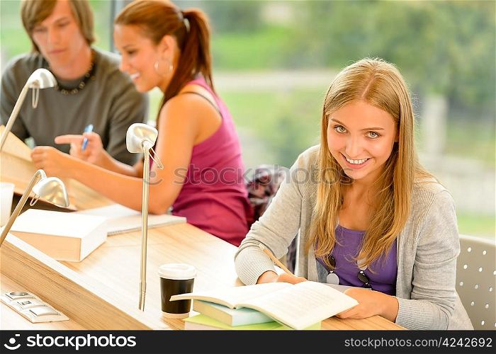 Student taking notes in study room smiling education campus