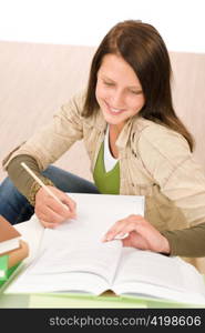 Student teenager happy girl write homework with book