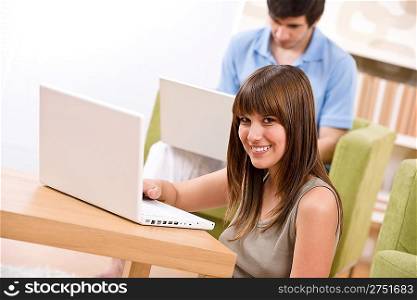 Student - two teenager with laptop in living room, on green armchair