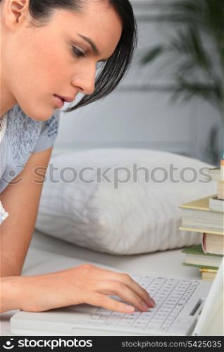 Student with a pile of books and a laptop computer