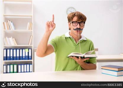 Student with fake moustache reading book