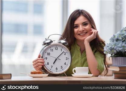 Student with gian alarm clock preparing for exams