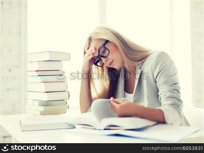student with pile of books and notes studying indoors. student with books and notes