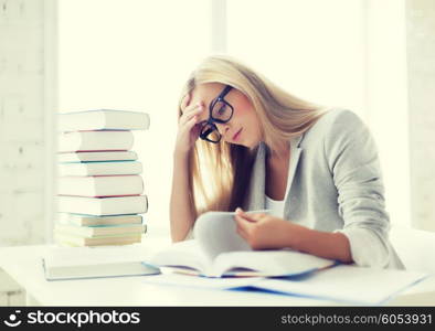 student with pile of books and notes studying indoors. student with books and notes