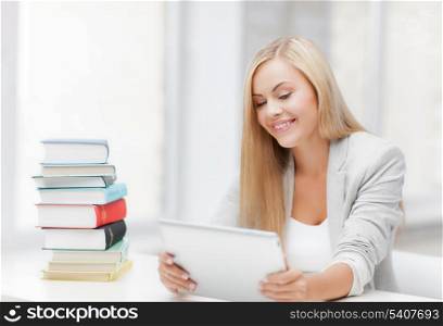 student with tablet pc and stack of books