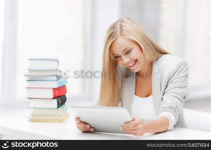 student with tablet pc and stack of books