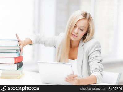 student with tablet pc pushing away stack of books