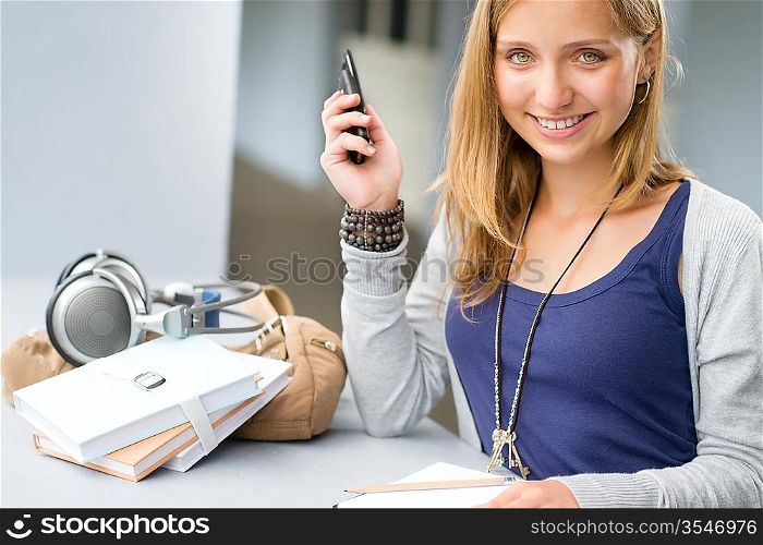 Student woman with notes and cellphone smiling teenage girl