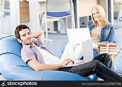 Students at high school or university relax with laptop studying
