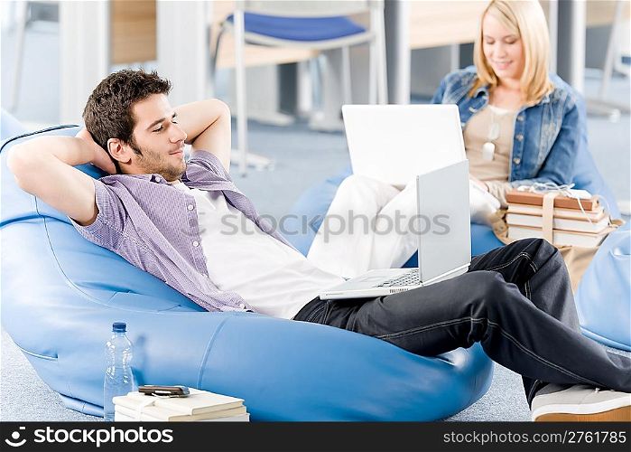 Students at high school or university relaxing with laptop studying