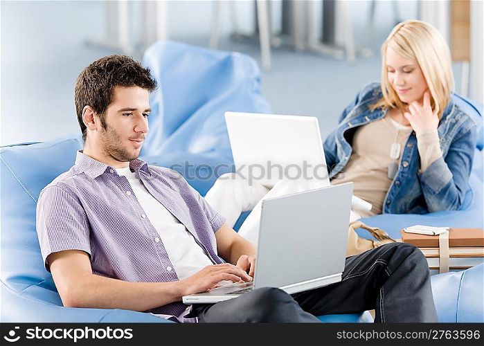 Students at high school or university working on laptop studying