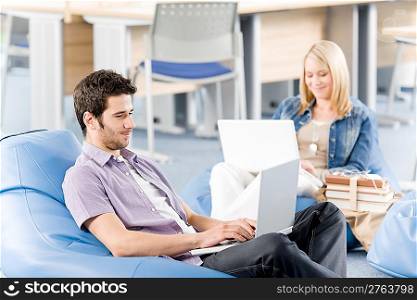 Students at high school or university working on laptop studying