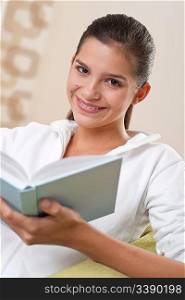 Students - Female teenager reading book in modern living room