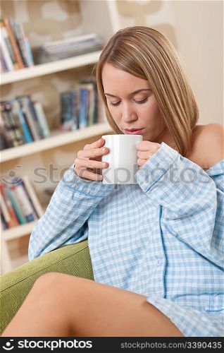 Students - Female teenager wearing pajamas and having cup of coffee