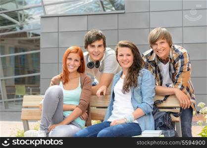 Students friends sitting bench outside campus smiling at camera