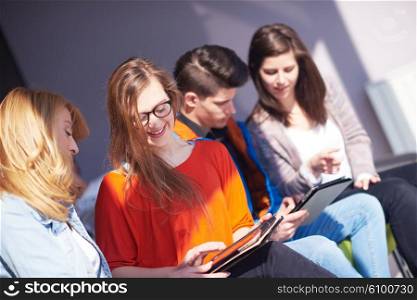 students group working on school project together on tablet computer at modern university