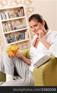 Students - Happy female teenager with potato chips in modern living room