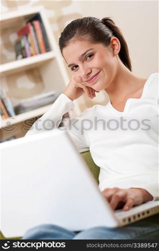 Students - Happy teenager with laptop in modern lounge sitting on armchair