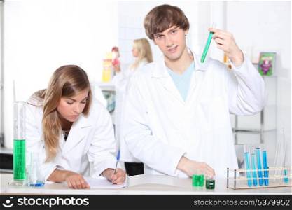 Students in a chemistry class with test tubes and other lab equipment