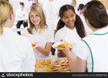Students in cafeteria line being served by lunch ladies