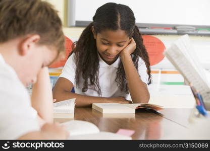 Students in class reading books (selective focus)