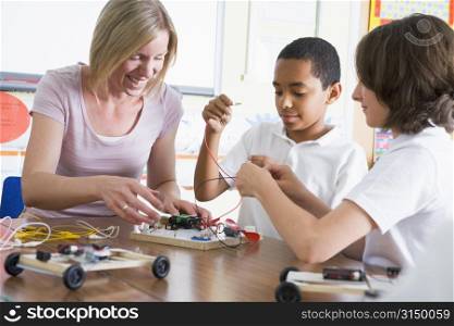 Students in class with teacher making electronic cars