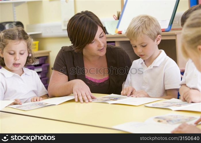 Students in class with teacher reading (selective focus)
