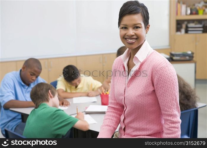 Students in class writing with teacher in foreground (selective focus)