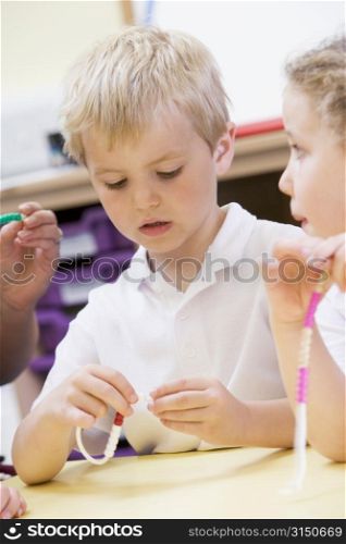 Students in math class using counting beads (selective focus)