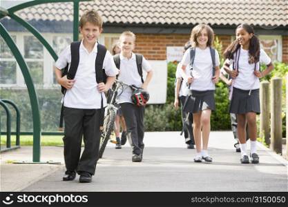 Students leaving school one with a bicycle