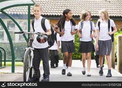 Students leaving school one with a bicycle