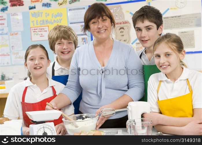 Students preparing ingredients in cooking class with teacher