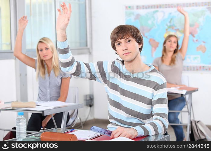 Students raising their hands in class